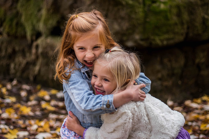 two siblings hugging outdoors